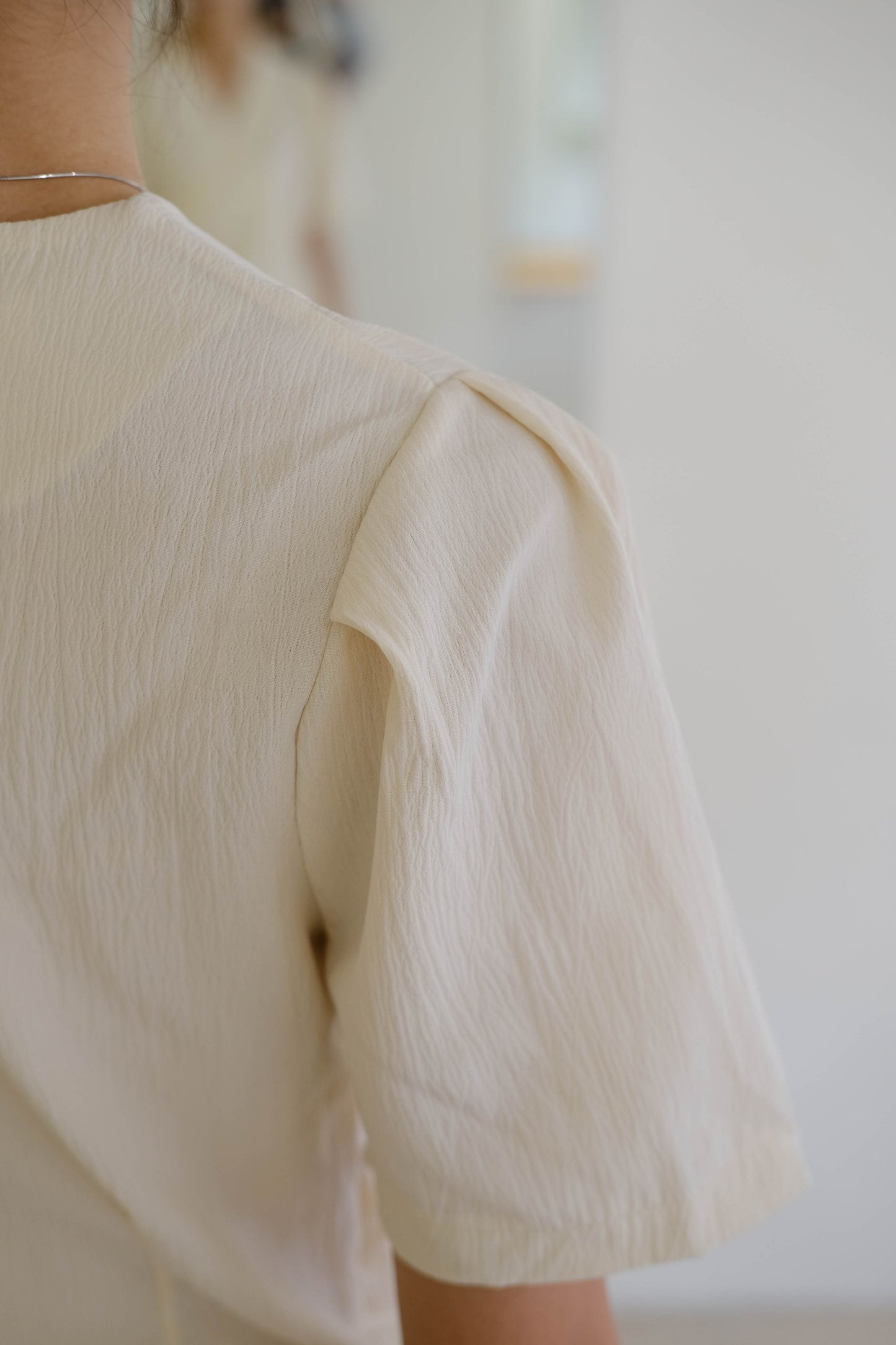 Irregular design pleated waist short-sleeved shirt in cream white